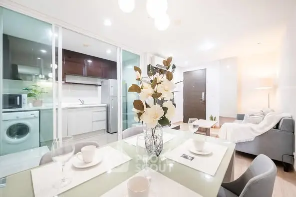 Modern open-plan living and dining area with sleek kitchen and cozy decor.