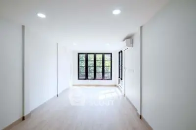 Spacious minimalist living room with large windows and natural light