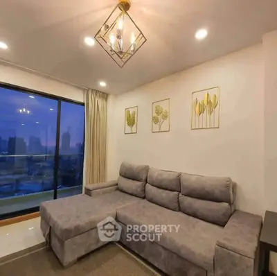 Modern living room with stylish gray sofa and city view balcony, perfect for urban living.