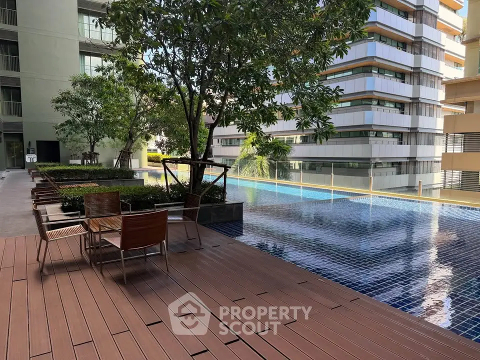 Luxurious apartment complex with serene poolside and modern architecture.