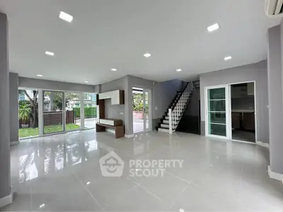 Spacious modern living room with garden view and sleek interior design.