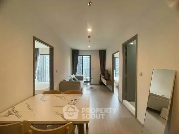 Modern open-plan living and dining area with natural light and stylish decor.