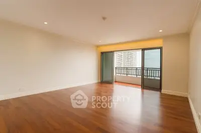 Spacious empty living room with hardwood floors and balcony view