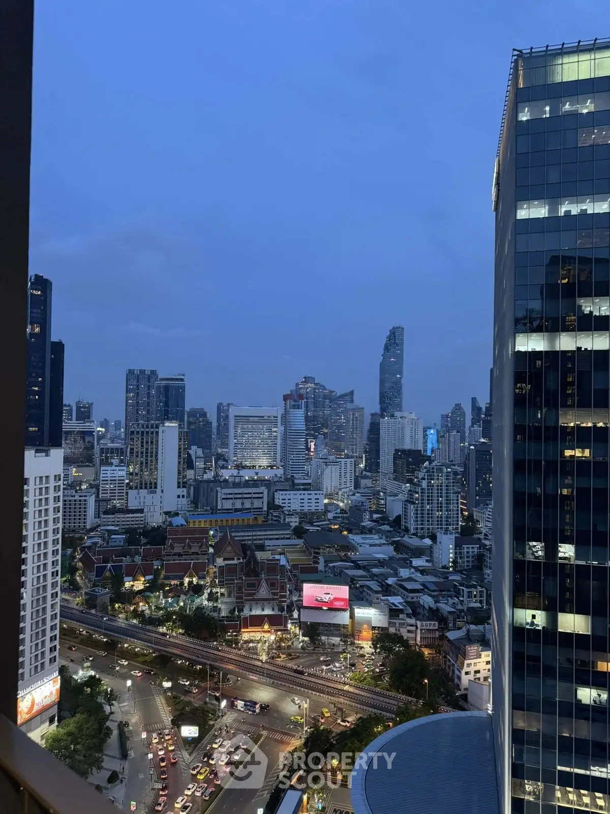 Stunning cityscape view from a high-rise building at dusk, showcasing urban skyline and vibrant city life.