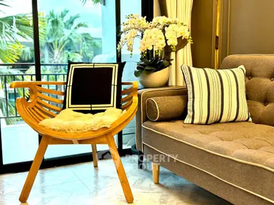 Stylish living room with modern chair and cozy sofa near large window with garden view.