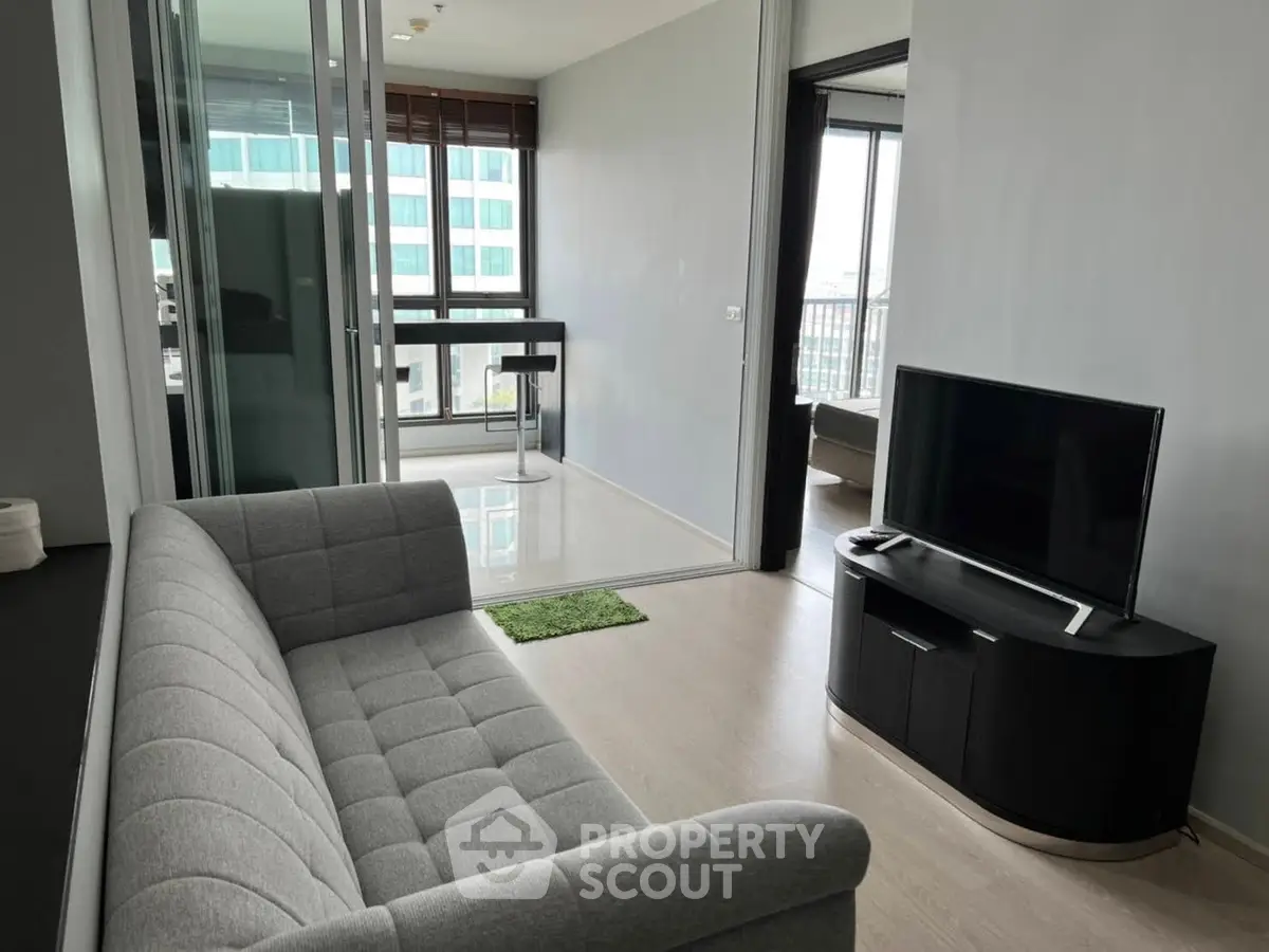 Modern living room with sleek furniture and large windows offering city views