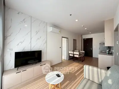 Modern living room with TV, stylish furniture, and open kitchen layout