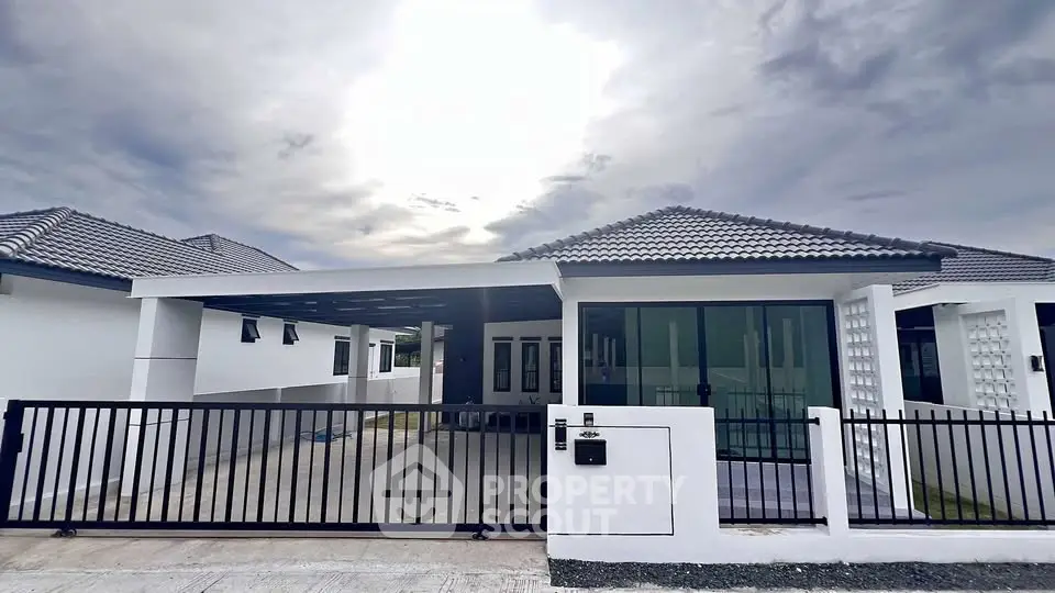 Modern single-story house with sleek design and spacious driveway.