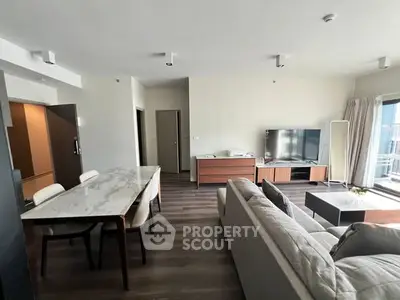 Spacious modern living room with elegant furniture and large TV, perfect for relaxation and entertainment.