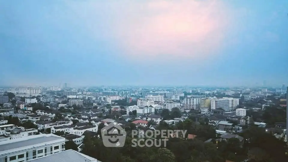 Stunning panoramic cityscape view from high-rise building at dusk, showcasing urban skyline and serene sunset.
