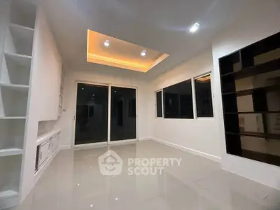 Modern living room with recessed lighting and large windows