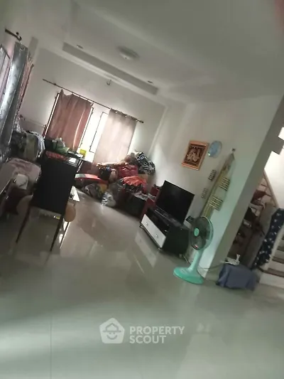 Spacious living room with modern decor and natural light, ideal for family gatherings.