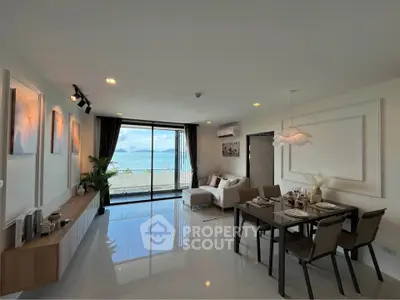 Spacious living room with ocean view, modern decor, and dining area in a luxury apartment.