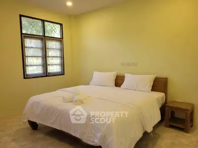 Cozy bedroom with double bed and natural light from window
