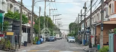 Charming residential street with row houses and parked cars, ideal for urban living.