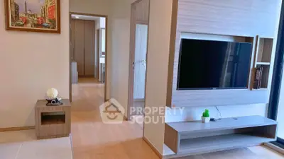 Modern living room with sleek TV unit and wooden flooring in a stylish apartment.