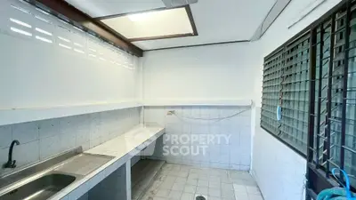 Spacious kitchen with tiled countertops and large windows for natural light.
