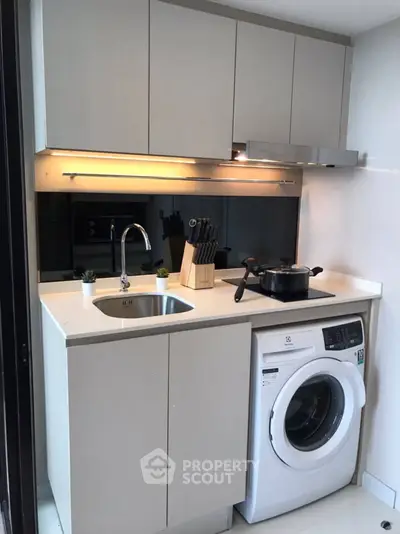 Modern compact kitchen with washing machine and sleek cabinetry