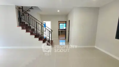 Spacious modern living room with elegant staircase and glossy tiled floors