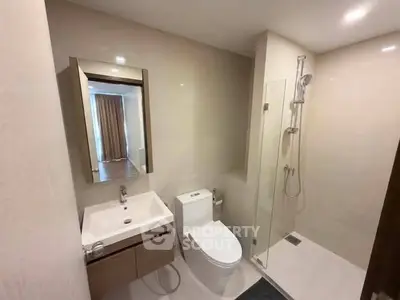Modern bathroom with sleek fixtures and glass shower in contemporary apartment.