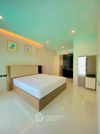 Spacious modern bedroom with minimalist design and ample natural light.