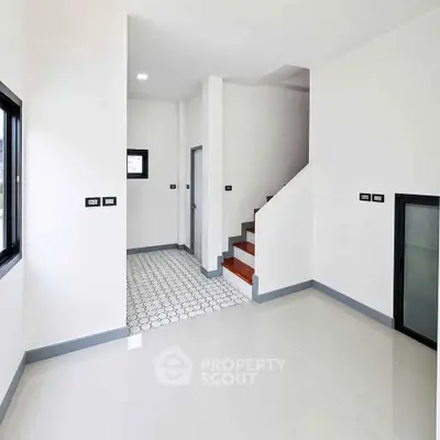 Modern minimalist interior with sleek staircase and tiled flooring, perfect for contemporary living.