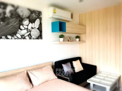 Modern bedroom with stylish decor and cozy seating area, featuring elegant wall art and air conditioning.