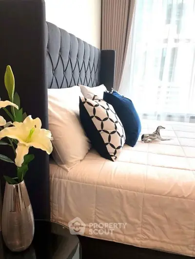 Elegant bedroom with stylish decor and plush bedding in modern apartment.