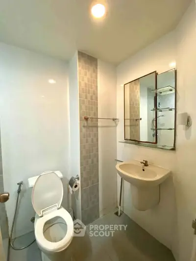 Modern bathroom with sleek fixtures and minimalist design, featuring a wall-mounted sink and toilet.
