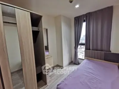 Modern bedroom with large window and built-in wardrobe