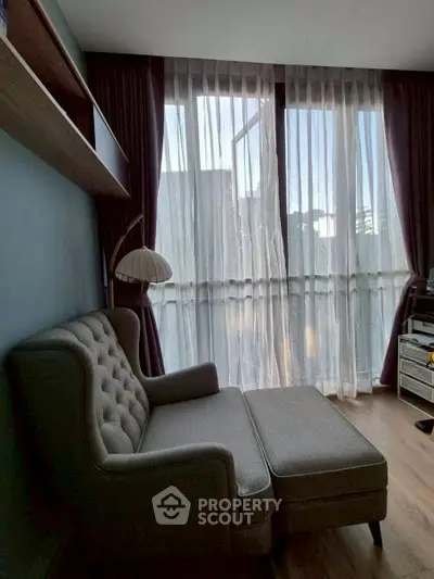 Cozy living room with elegant armchair and floor-to-ceiling windows