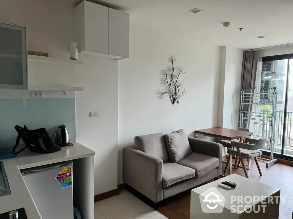 Modern living room with cozy sofa and dining area, featuring natural light and minimalist decor.