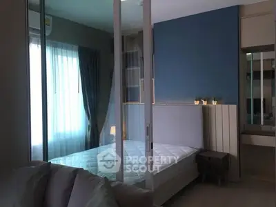 Modern bedroom with glass partition and natural light in stylish apartment.