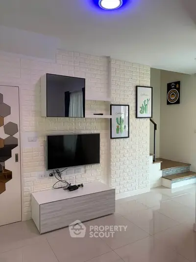 Modern living room with sleek TV setup and stylish decor in a contemporary home.