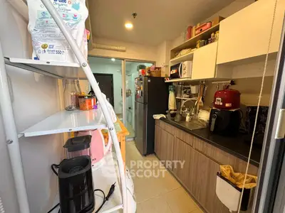 Modern kitchen with sleek cabinetry and appliances, featuring a coffee maker and ample storage space.