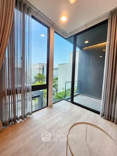 Modern living room with floor-to-ceiling windows and balcony view