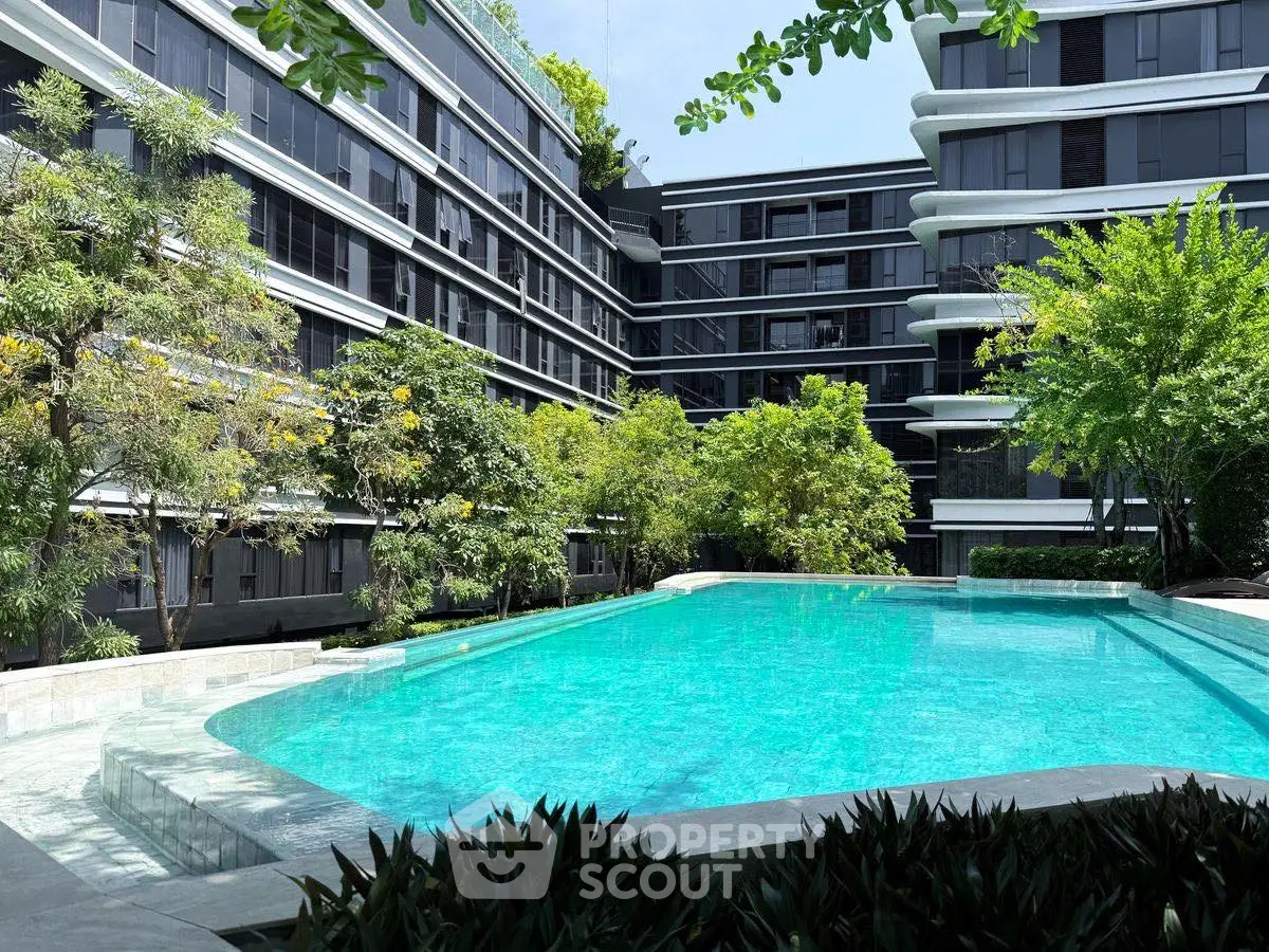 Luxurious apartment complex with a stunning outdoor pool and lush greenery.