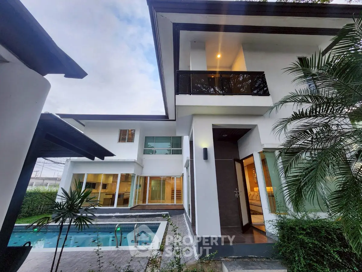 Modern two-story house with pool and lush greenery