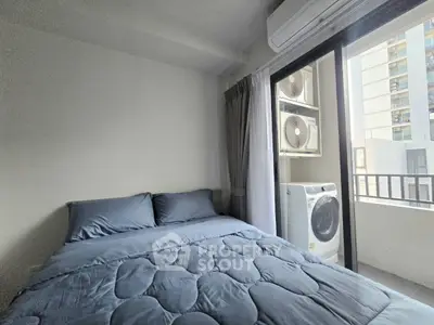 Cozy bedroom with balcony access and modern appliances in urban apartment