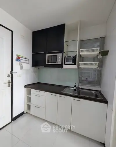 Modern kitchen with sleek cabinets and built-in microwave, perfect for urban living.