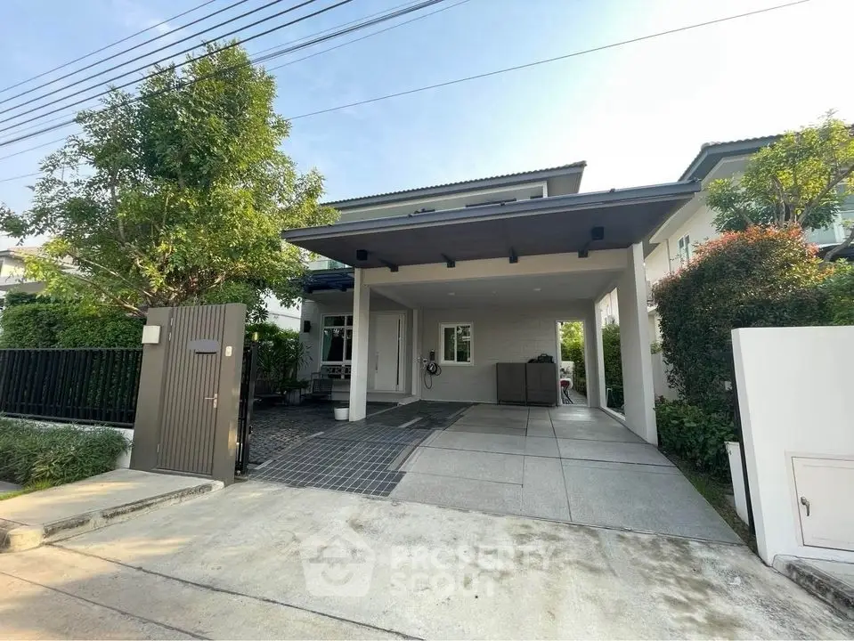 Modern house exterior with spacious driveway and lush greenery