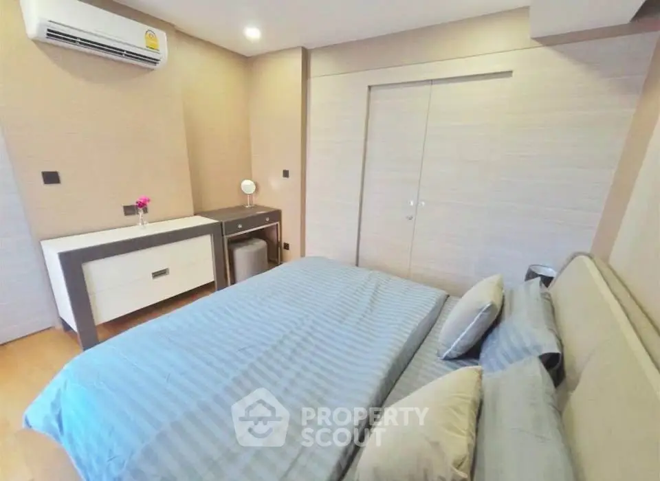Modern bedroom with stylish decor and air conditioning in a cozy apartment.