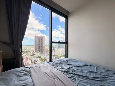 Stunning bedroom with panoramic city view from high-rise window, featuring cozy bedding and modern design.