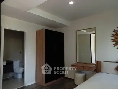 Modern bedroom with ensuite bathroom, featuring sleek furniture and minimalist design.