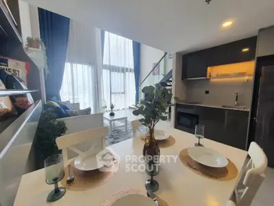Modern open-plan living and dining area with high ceilings and large windows.
