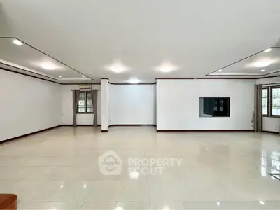 Spacious empty living room with large windows and modern lighting