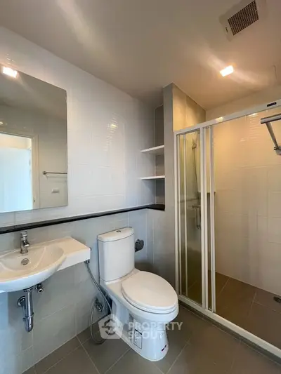 Modern bathroom with sleek shower and elegant fixtures in a contemporary apartment.