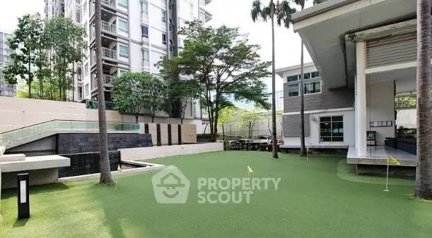 Luxurious condominium exterior with lush green garden and modern architecture.