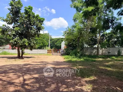 Spacious land plot with lush greenery and clear blue sky, ideal for development.