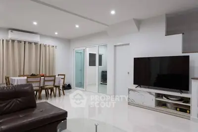 Spacious modern living room with sleek furniture and dining area, perfect for family gatherings.